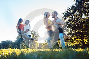 Two couples dancing kizomba during sunset in a park