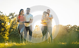 Two couples dancing kizomba during sunset in a park