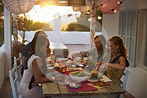 Two couples eating dinner at a table on a rooftop terrace