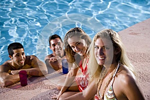 Two couples hanging out in swimming pool