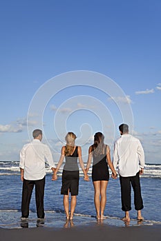 Two Couples, Holding Hands On A Beach