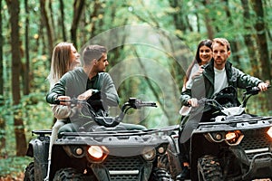 Two couples on a quad bike in the forest during the day