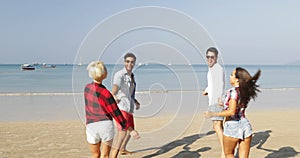 Two couples running on beach to water man hold woman hands happy cheerful people tourists on vacation