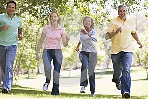 Two couples running outdoors smiling