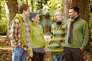 Two couples talking in autumn forest