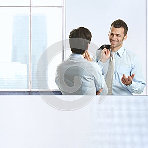 Two coworkers chatting in office photo