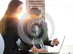 Two coworkers discussing fun project over a laptop