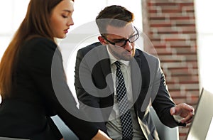 Two coworkers discussing fun project over a laptop