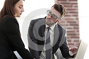 Two coworkers discussing fun project over a laptop