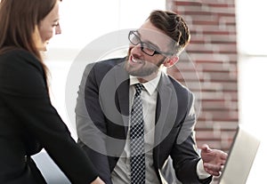 Two coworkers discussing fun project over a laptop