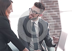 Two coworkers discussing fun project over a laptop