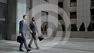 Two coworkers leaving business center after meeting with partners, business photo