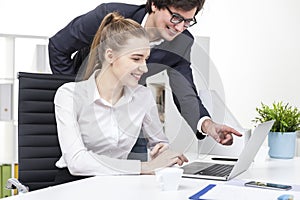 Two coworkers watching a funny video at lunch break