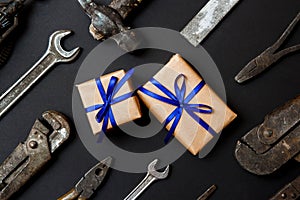 Two craft gifts with vintage old tools on black paper background. Fathers day concept. Flat lay