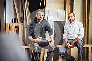 Two craftsmen are taking a break in a workshop