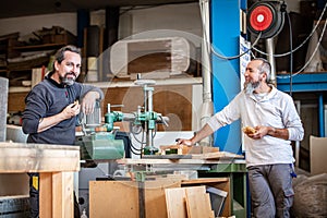 Two craftsmen are taking a break in a workshop