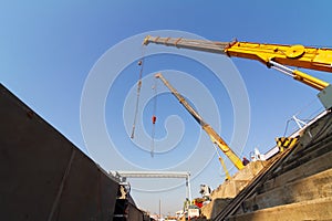 Two crane working over dry dock against blue sky