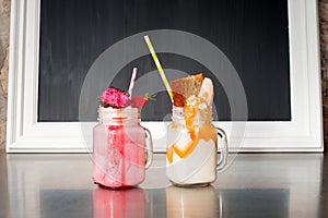 Two crazy milkshakes, with a blank blackboard