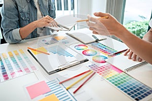 Two creative graphic designer team working on color selection and drawing on graphic tablet, Color swatch samples chart for
