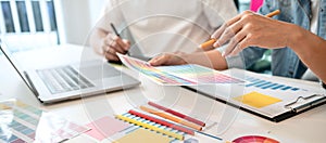 Two creative graphic designer team working on color selection and drawing on graphic tablet, Color swatch samples chart for