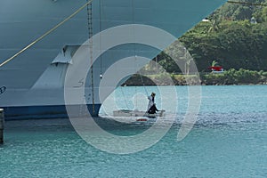 Two crewmembers are painting white the bow of cruise passenger vessel in port of Castries, St Lucia. photo