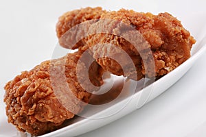 Two crispy fried chicken drumsticks