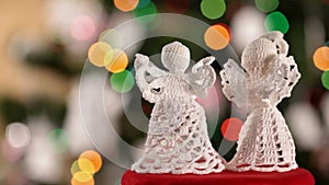 Two crocheted xmas angels decorations on blinking lights background