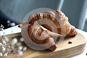 Two croissant in the wooden desk on a morning