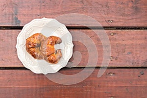 Two croissants on a decorated plate.