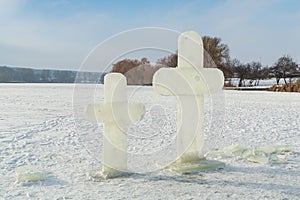 Two cross carved from ice on a winter lake near the ice hole at Epiphany