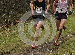 Two cross country runners racing in the rain