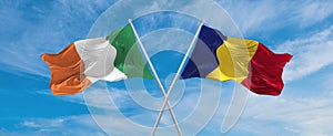 two crossed flags romania and Ireland waving in wind at cloudy sky. Concept of relationship, dialog, travelling between two