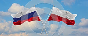 two crossed flags Russia and Poland waving in wind at cloudy sky. Concept of relationship, dialog, travelling between two