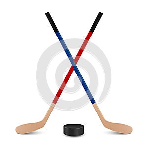 Two crossed hockey sticks and puck.