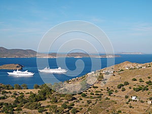 Two cruise ships moving into the port city of Skala in Patmos, Greece