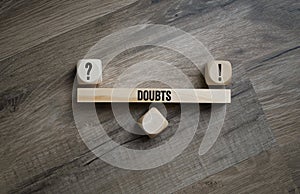 Two cubes, dice or blocks with question and answer with doubt on wooden background