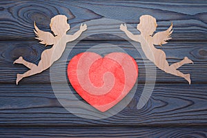 Two cupids and a red heart made of wood texture. photo