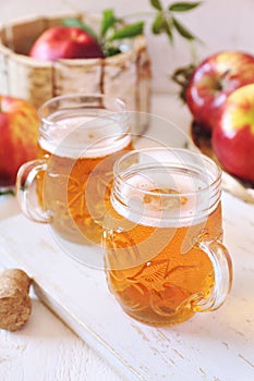 Two cups of Apple Cider and red apples