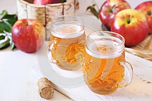 Two cups of Apple Cider and red apples