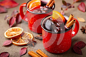 Two cups of autumn mulled wine or gluhwein with spices and orange slices on rustic table top view. Traditional drink on autumn hol