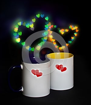 Two cups on a black background with bokeh