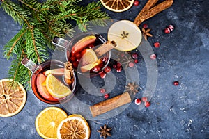 Two cups of christmas mulled wine or gluhwein with spices and orange slices on rustic table top view. Traditional drink on winter