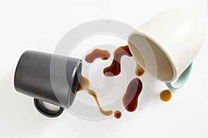 two cups of coffee with brown spill on white background