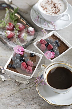 Two cups of coffee, chocolate desserts and strawberries, vintage cutlery