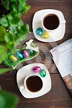 Two cups of coffee with chocolate eggs in Easter morning