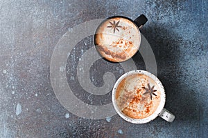 Two cups of coffee with crema, cinnamon and badian on dark background