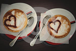 Two cups of coffee with heart pattern