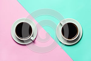 Two cups of coffee on minimalistic blue and pink background. Top view, flat lay. Minimalism coffee concept