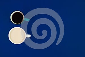 Two cups with different kinds of coffee on a blue background with empty space, minimalistic composition with hot beverages, top