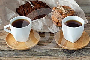 Two cups of freshly brewed espresso on wooden table. coffee beans on light wooden table  rustic style  homemade